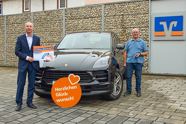 Geschäftsstellenleiter Wolfgang Schwinger (links) übergibt dem glücklichen Gewinner den Schlüssel für seinen nagelneuen Porsche Macan.